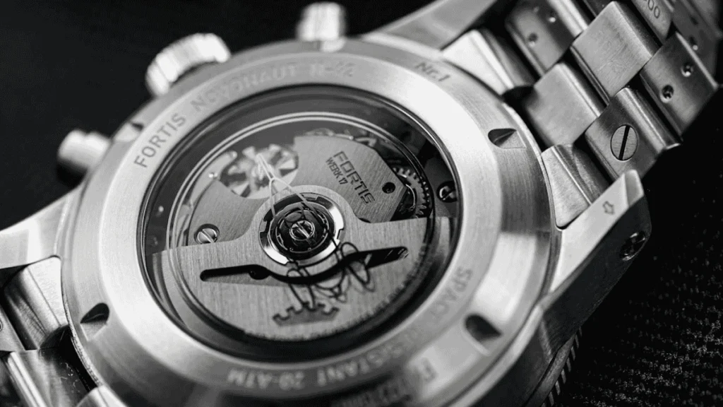 Foto em close (macro) da tampa traseira de um relógio original exibindo nitidez nas gravações do número de série e marca.